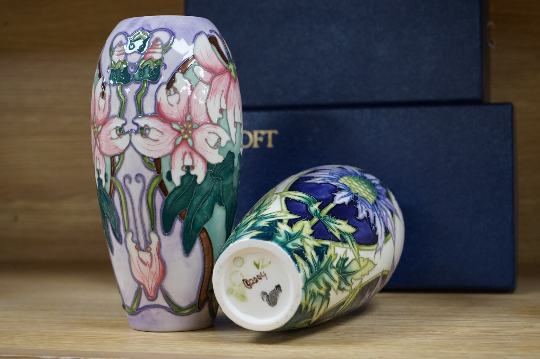Two Moorcroft vases, Blakeney and a Caledonia patterns, both boxed, 18.5cm